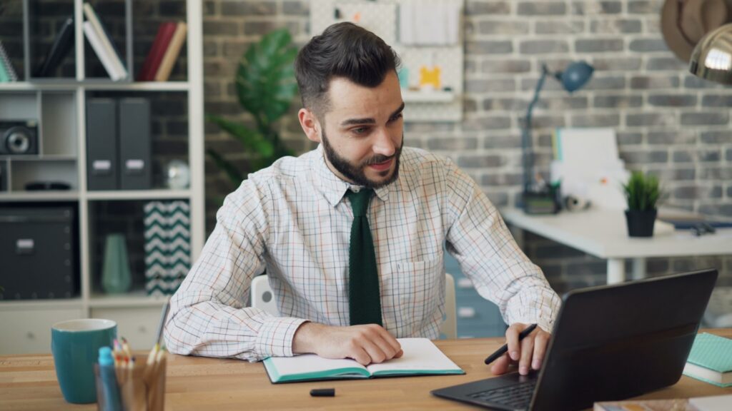 Man werkt op laptop op kantoor - Microsoft Office 365 vs Office 2021